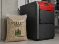 Nowoczesny piec na pellet premium obok worka z paliwem. Idealny do ogrzewania domu przez cały rok.