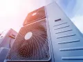Pompa ciepła 8kw na ile metrów? Widok z dołu na kilka jednostek klimatyzacyjnych na tle błękitnego nieba.