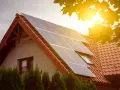 Panele słoneczne na dachu domu. To przykład, jak działa prosument, produkując własną energię.