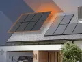 Rozbudowa instalacji fotowoltaicznej z dwoma falownikami na dachu domu. Panele słoneczne generują energię.