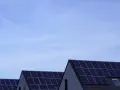 Dachy domów pokryte panelami fotowoltaicznymi. Stabilizator napięcia fotowoltaika zapewnia optymalną pracę instalacji.
