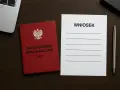 Czerwona książeczka z orłem i napisem "Zaświadczenie Kwalifikacyjne UDT" obok formularza "Wniosek" i długopisu. Przygotowanie do przedłużenia uprawnień UDT.