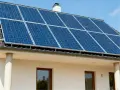 Panele fotowoltaiczne na dachu domu, zapewniające czystą energię. To przyszłość, czyli fotowoltaika hybrydowa.
