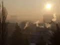 Mglisty poranek, słońce przebija się przez dym z kominów. Czas pomyśleć, do kiedy trzeba wymienić piec, by powietrze było czystsze.