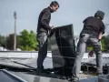 Pracownicy montują panele fotowoltaiczne, przygotowując zgłoszenie rozbudowy instalacji fotowoltaicznej PGE.