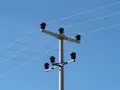 Słup energetyczny z izolatorami, na którym widać przewody elektryczne. Taryfa B23 może być związana z takim właśnie zasilaniem.