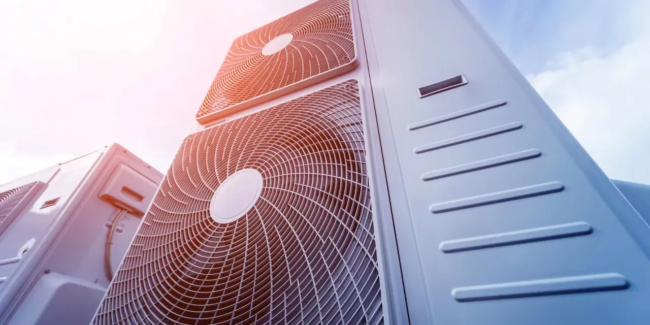 Pompa ciepła 8kw na ile metrów? Widok z dołu na kilka jednostek klimatyzacyjnych na tle błękitnego nieba.