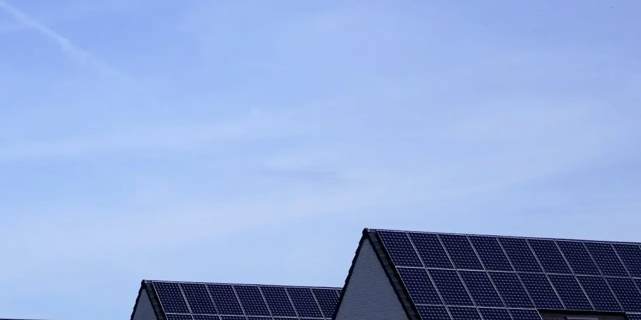 Dachy domów pokryte panelami fotowoltaicznymi. Stabilizator napięcia fotowoltaika zapewnia optymalną pracę instalacji.