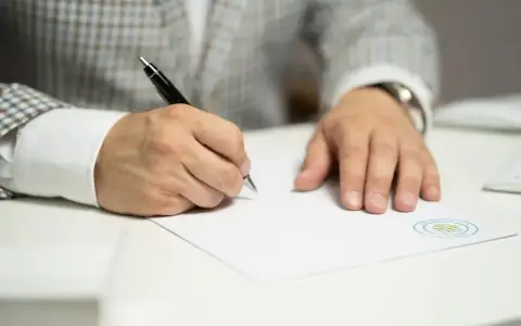 Mężczyzna w eleganckiej marynarce podpisuje dokument, być może umowę na taryfę g11k.