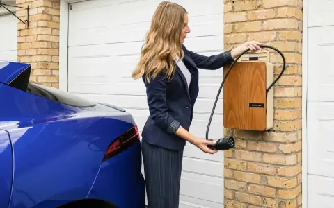 Kobieta podłącza niebieski samochód elektryczny do ładowarki. Szybkie ładowanie dzięki sile 400V.