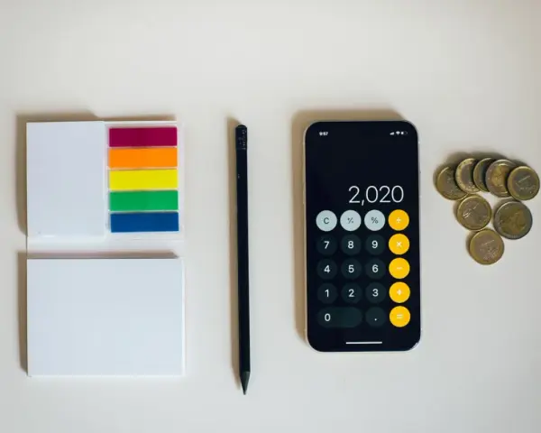 Kalkulator na telefonie pokazuje 2020, obok leżą monety euro. To może być początek oszczędzania na depozyt prosumencki.
