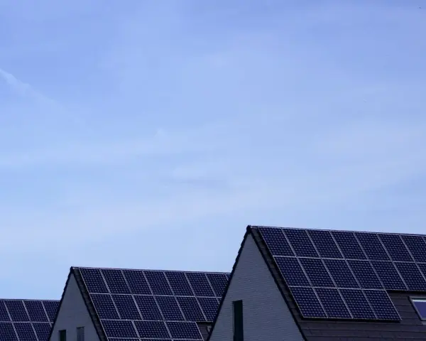 Dachy domów pokryte panelami fotowoltaicznymi. Stabilizator napięcia fotowoltaika zapewnia optymalną pracę instalacji.