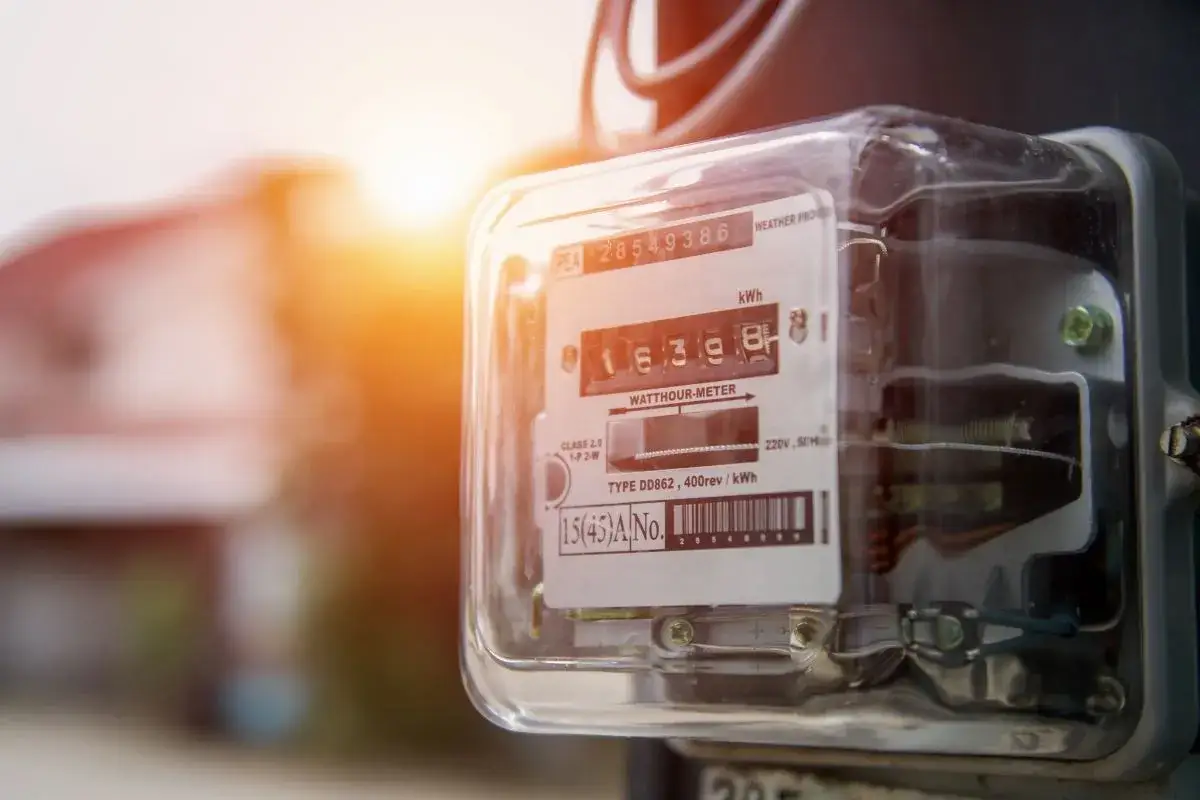 Licznik energii elektrycznej, idealny do taryfy weekendowej PGE. Słońce zachodzi za domem, a licznik pokazuje zużycie energii.