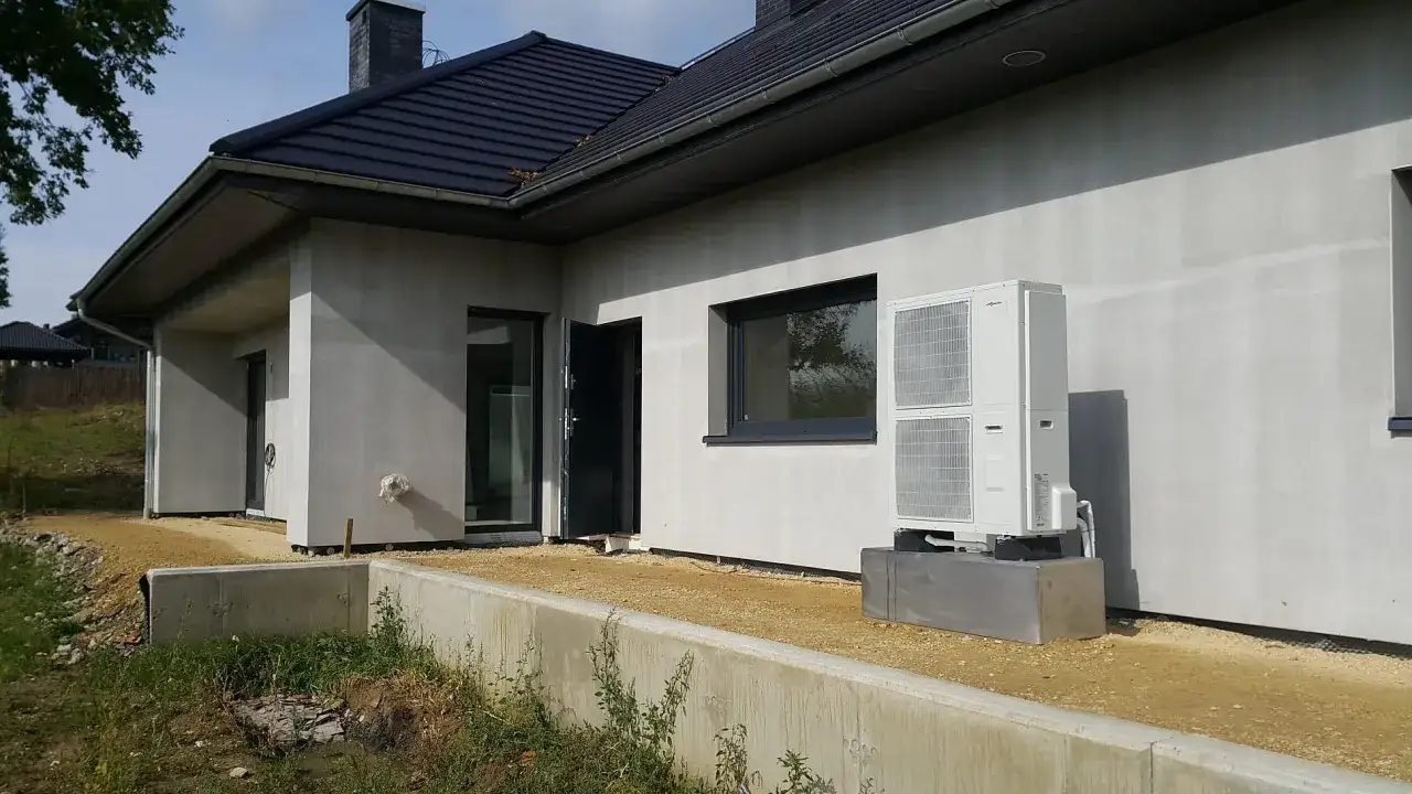 Nowy dom z pompą ciepła. Montaż pompy ciepła na nowoczesnym budynku, gotowym do zamieszkania.