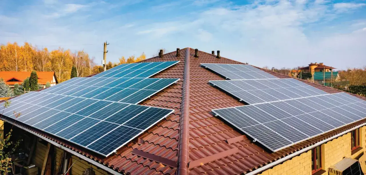 Panele słoneczne na brązowym dachu domu. Tigo zapewnia czystą energię.