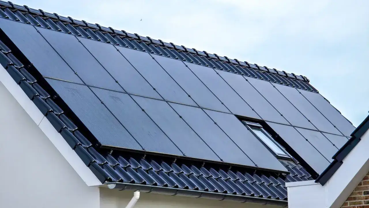 Na dachu domu zamontowano ciemne moduły monokrystaliczne, które zbierają energię słoneczną.